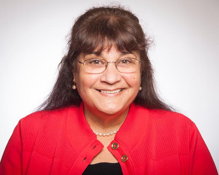 Marie Brancati Alt text: Woman in a red shirt smiling against a white background.