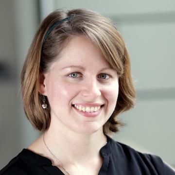 A person smiling against a neutral background.