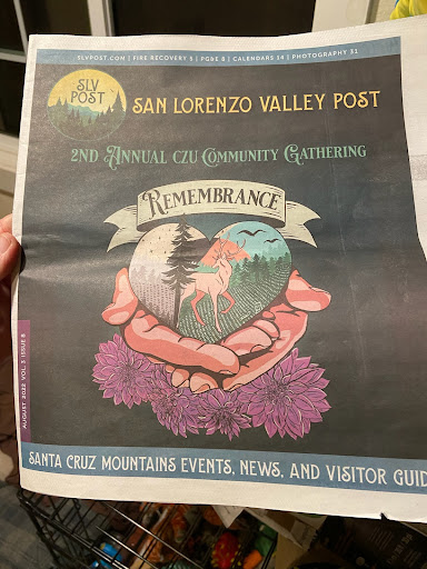 A person holding a newspaper featuring the section titled 