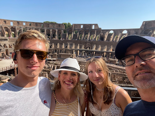 A group photo of four people at the Colosseum in Rome.