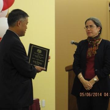 A person receiving an academic award plaque. 