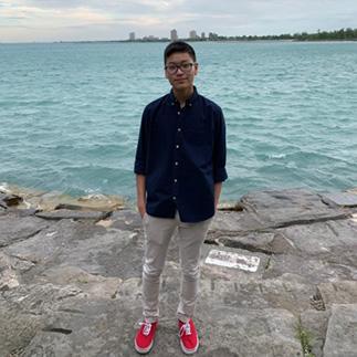 A person standing by the water with city skyline in background.