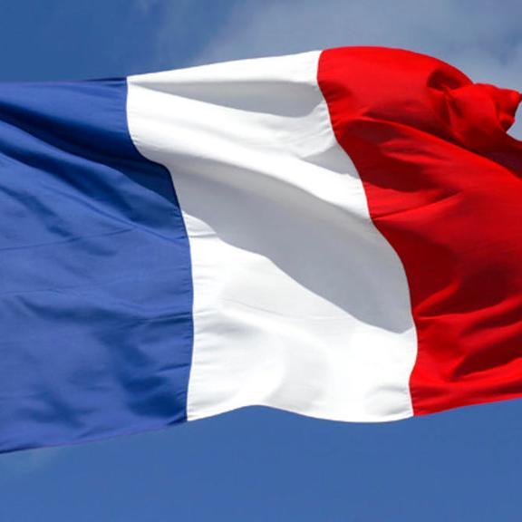 French flag waving against a blue sky