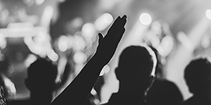 People of indistinct ethnicity praising and raising hands in prayer