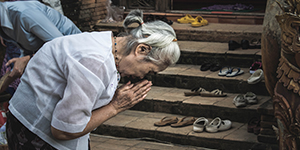 Woman bowing outside holy place