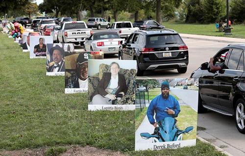 A roadside memorial with photos and flowers honoring Covid victims.