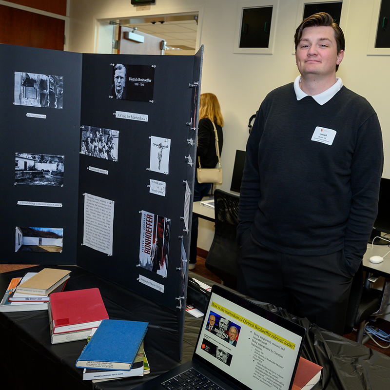 Joseph Barton stands beside his display on Dietrich Bonhoeffer