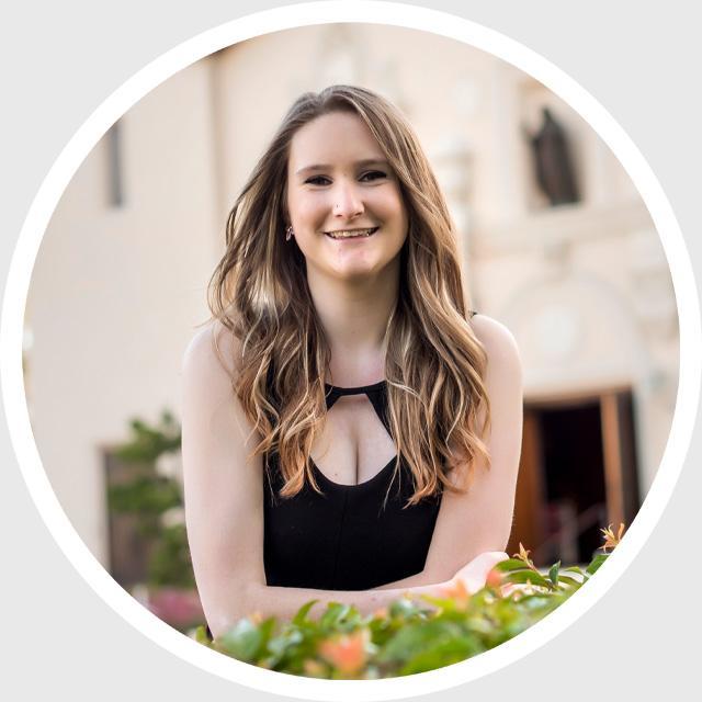 A person smiling with a blurred background inside a circular frame.