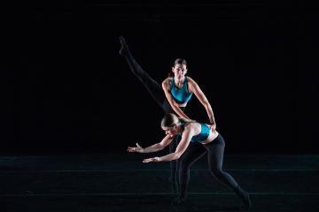 Female dancer using hands to jump off another female dancer