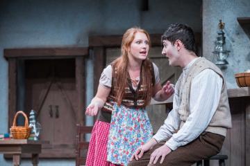 Helen angrily gestures at Bartley in a staged argument.