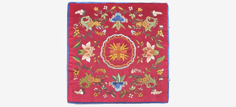 Red burse with colorful floral design.