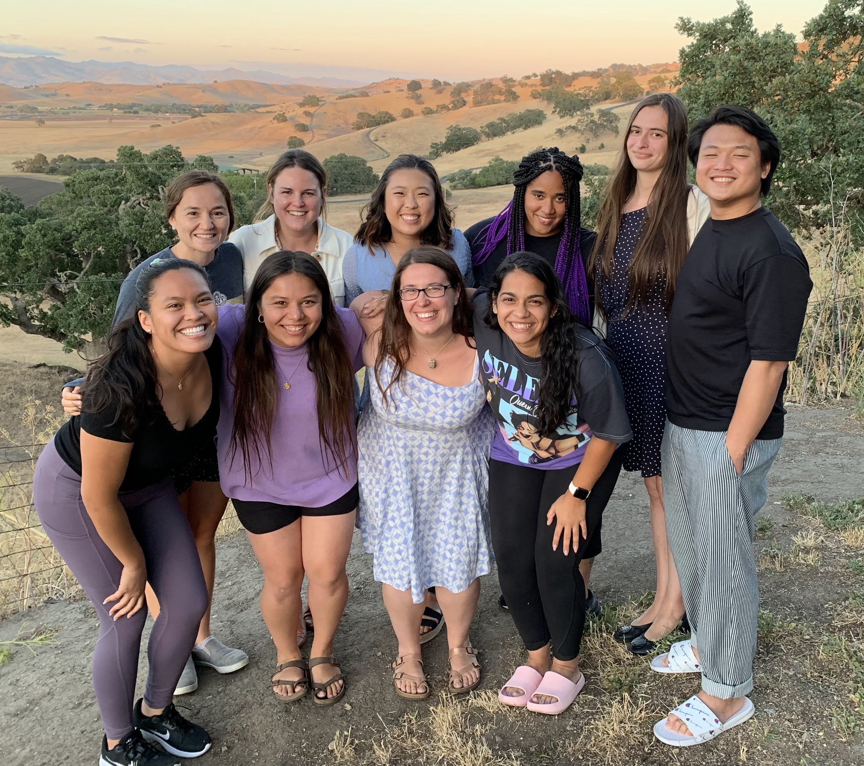 A group of people with smile on their faces looking at the camera 