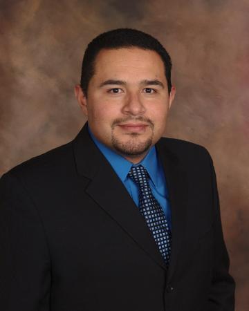 A man in a suit with a blue shirt and tie.