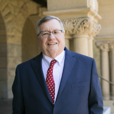 A man in a suit and tie standing outside a building. image link to story