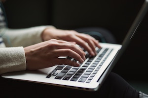 Hands typing on a computer keyboard 
