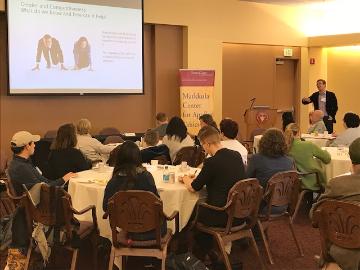 A speaker presenting to an audience at a conference.