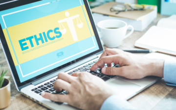 Man typing on laptop. The screen displays a website with the word, 