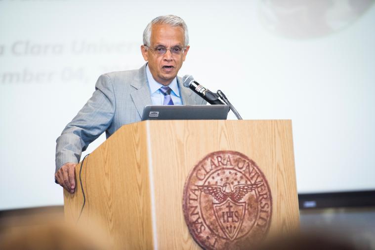 A man in a suit giving a speech at a podium.