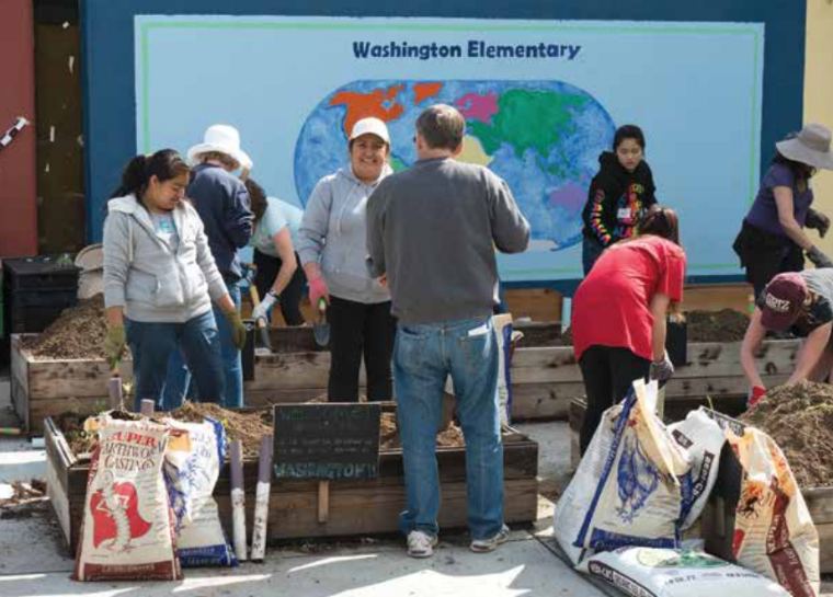 People working together in front of a mural with the text 