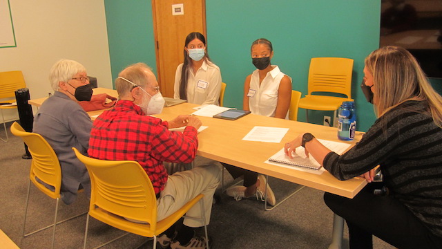 Leslie Cataño (left) and Kennedy Anderson talk with panel members.