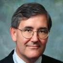 A man in a suit and tie with glasses.