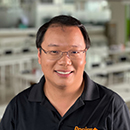 A person smiling in a casual indoor setting.