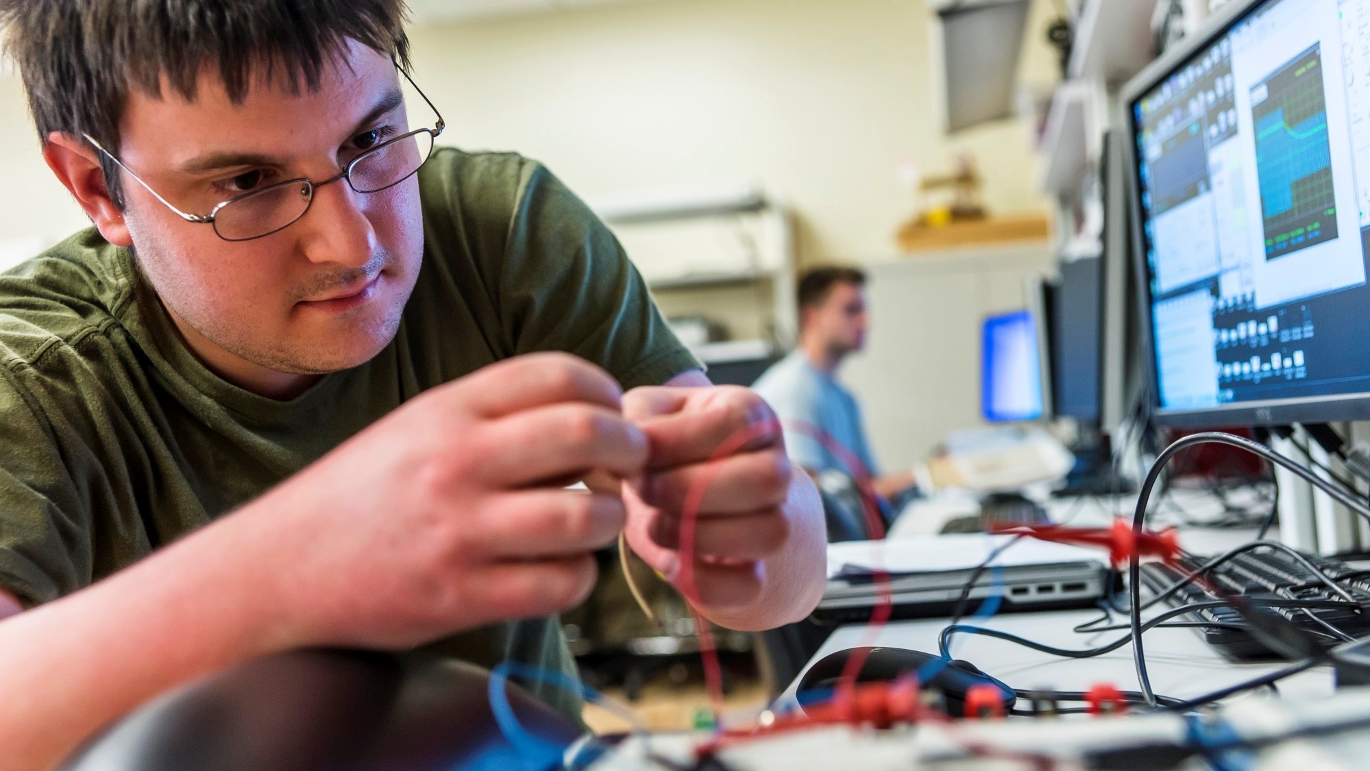 Santa Clara Engineering student attaching wires in a classroom 
