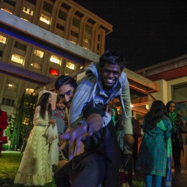 A SCU student picks up another student in celebration outside residential living 