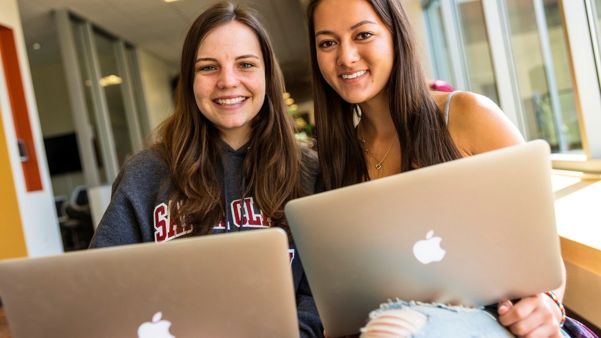 Two Santa Clara students on their laptops in the library 
