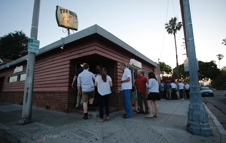 People standing outside a brick building titled 