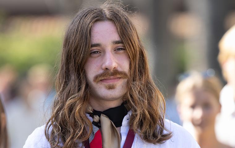 Simon Lanzoni wearing a white shirt, looking into the distance at the Senior Toast