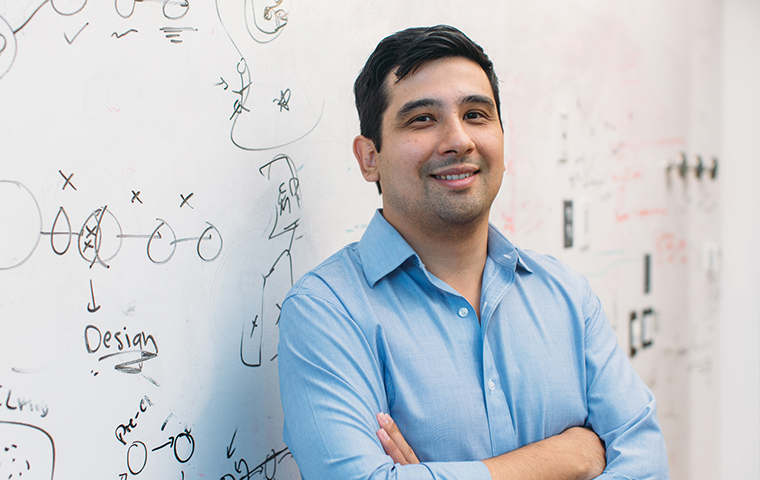 Photo of 2009 alumnus Jason Buenrostro in front of a whiteboard