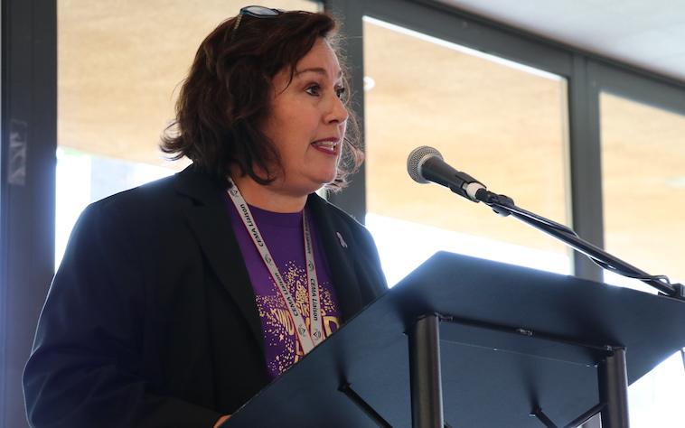 Carla Collins ’91 address conference on domestic violence.