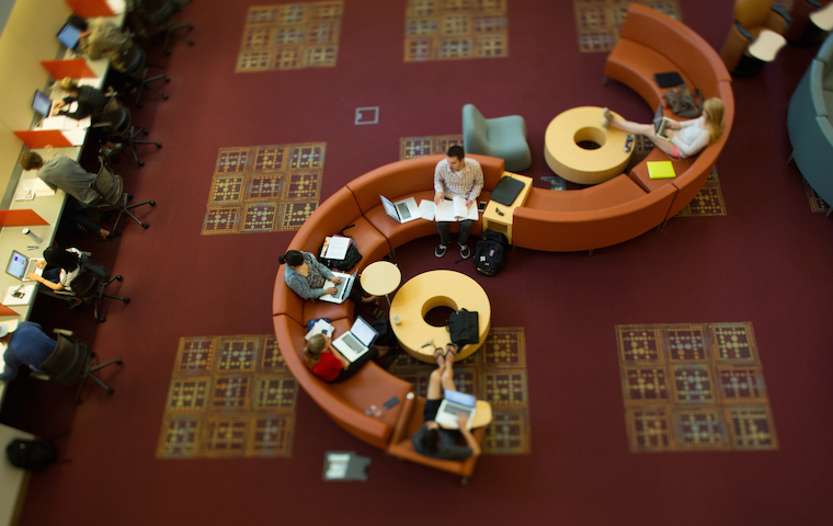 Alt text: Library interior with curved seating and red carpet. image link to story