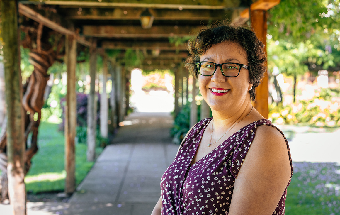 Professor Pearl Barros standing on walkway next to Mission Church