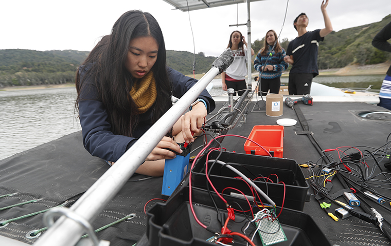 Taylor Mau connecting wires on boat