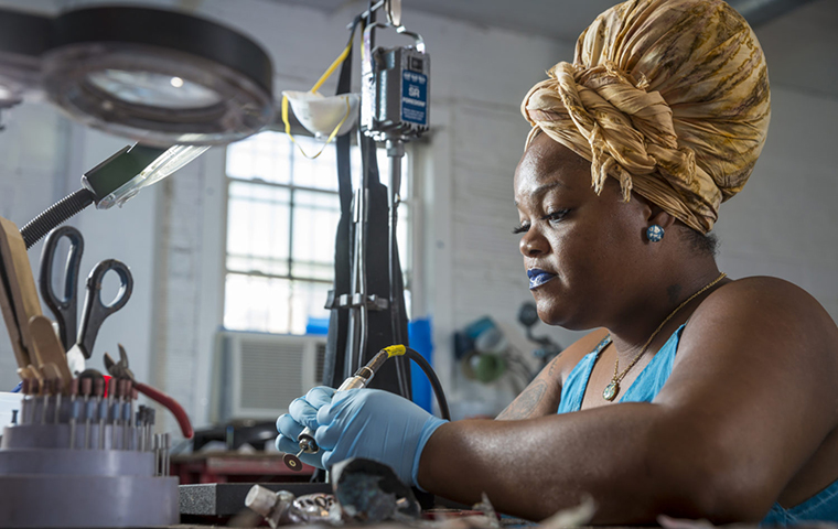 Woman making jewelry from fallen graffiti flakes