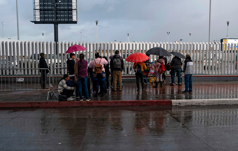 Asylum Seekers stand near fence