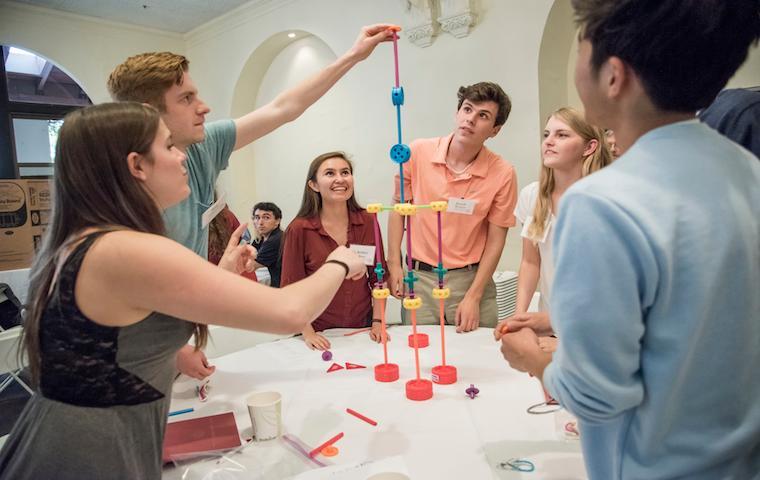 Group of people engaged in a collaborative activity in a room. image link to story