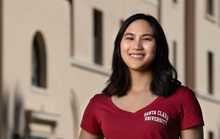 Kristi Nguyen standing in front of a building on campus