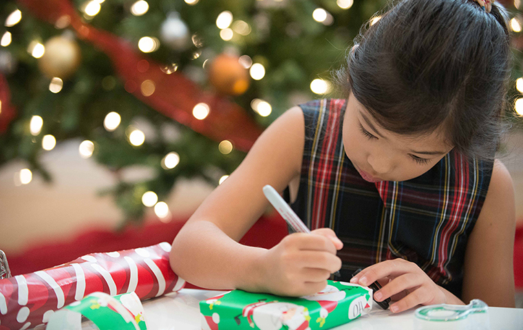 Lili Vossugh writing a label on a Christmas gift