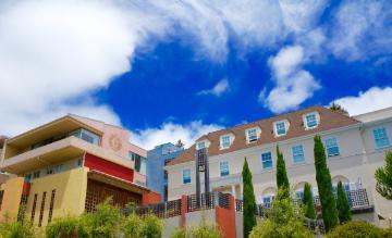 Jesuit School of Theology campus buildings under a blue sky with clouds.