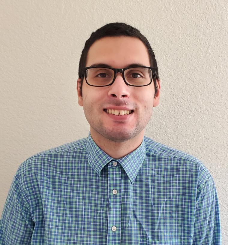 A person wearing glasses and a blue checkered shirt.