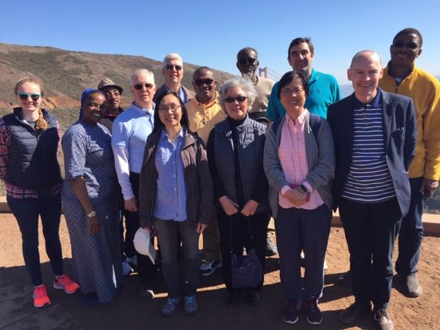 Group of people posing outdoors under the sun for a 