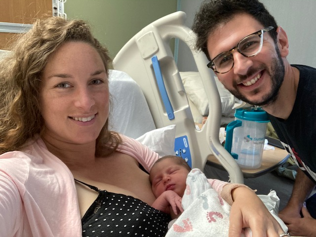 A happy family with a newborn in a hospital room.