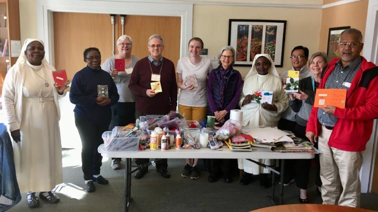 A group of people standing behind a table with displayed items.