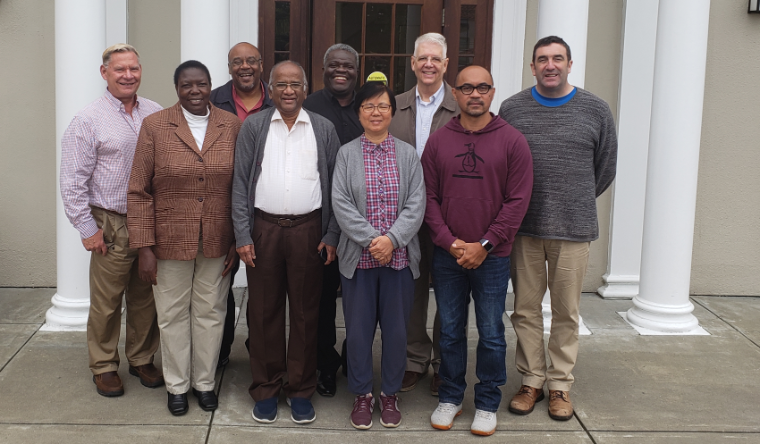 A group of ten people standing in front of a building.