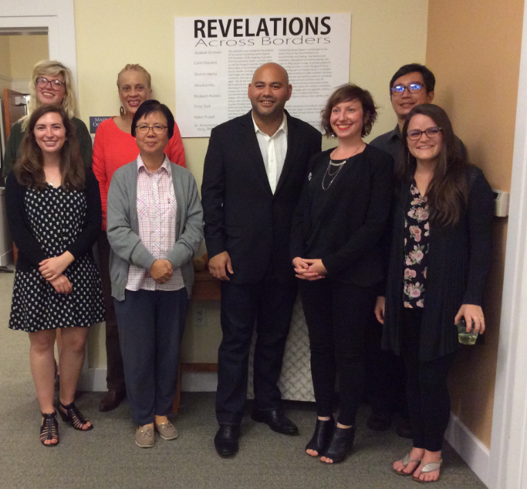 A group of people standing together below a 'Revelations' sign.