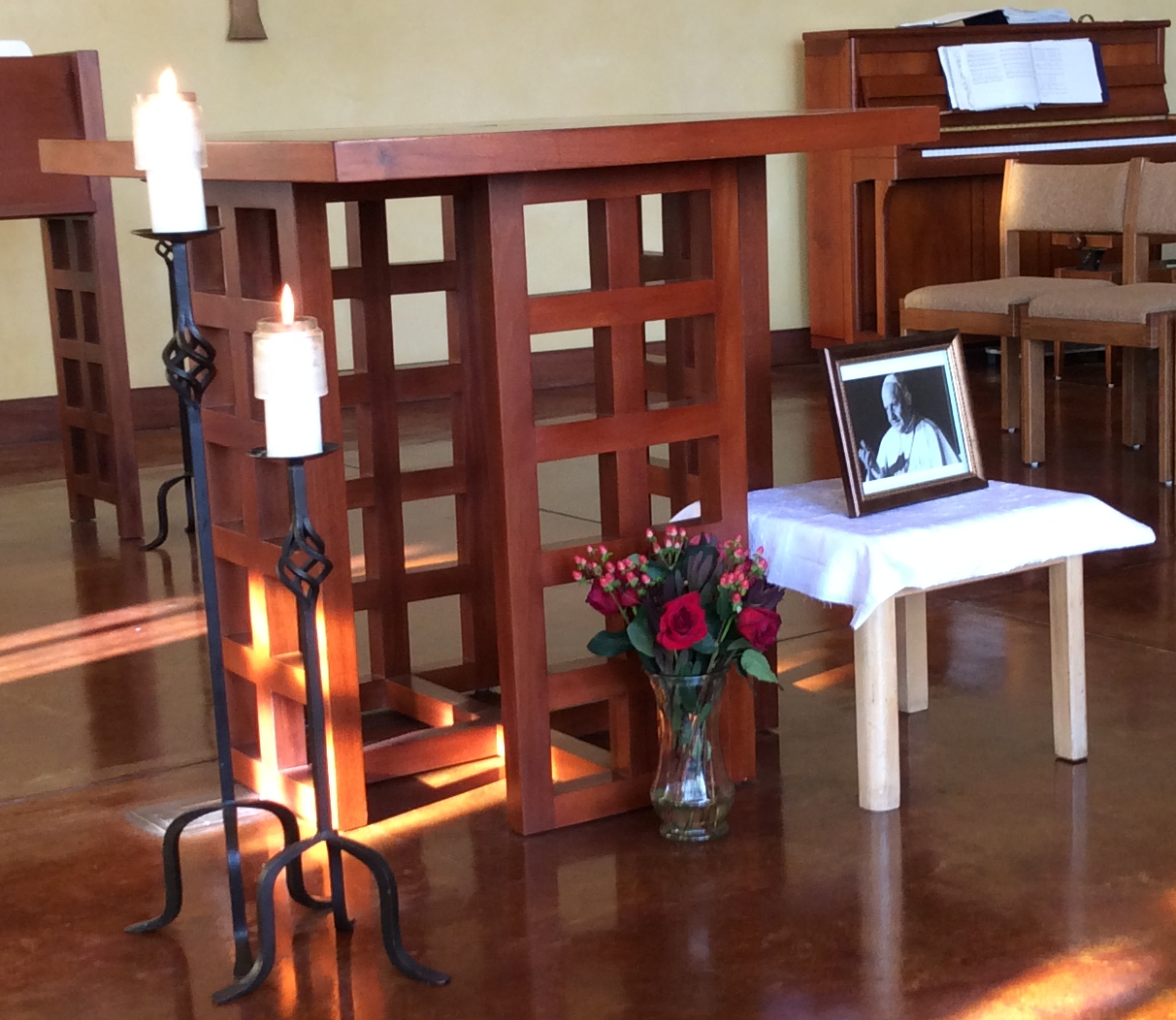 Altar for John XXIII with candles, flowers, and a photo.