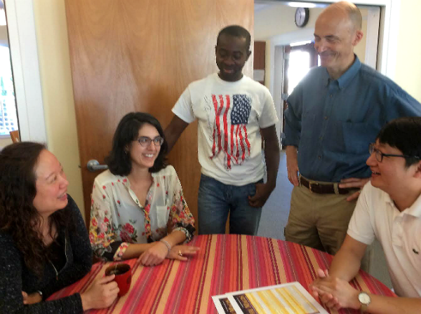 Five people at a table, smiling and talking.